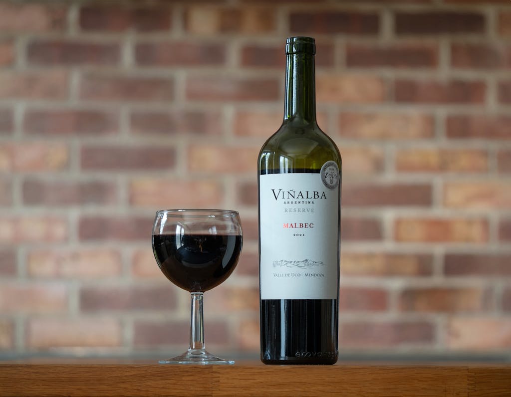 A bottle of wine and a glass of wine on a table